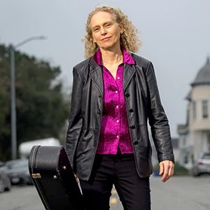 Mimi Fox carrying her guitar case portrait