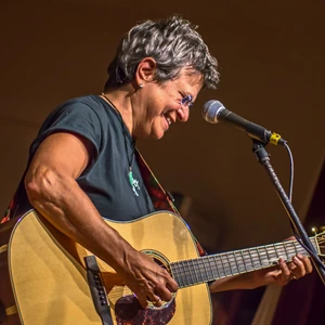 Tret Fure strumming her acoustic guitar